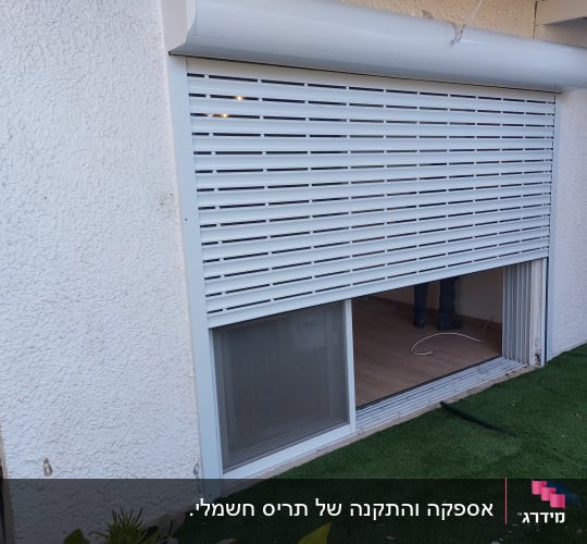 תריס אלומיניום לבן מותקן על חלון